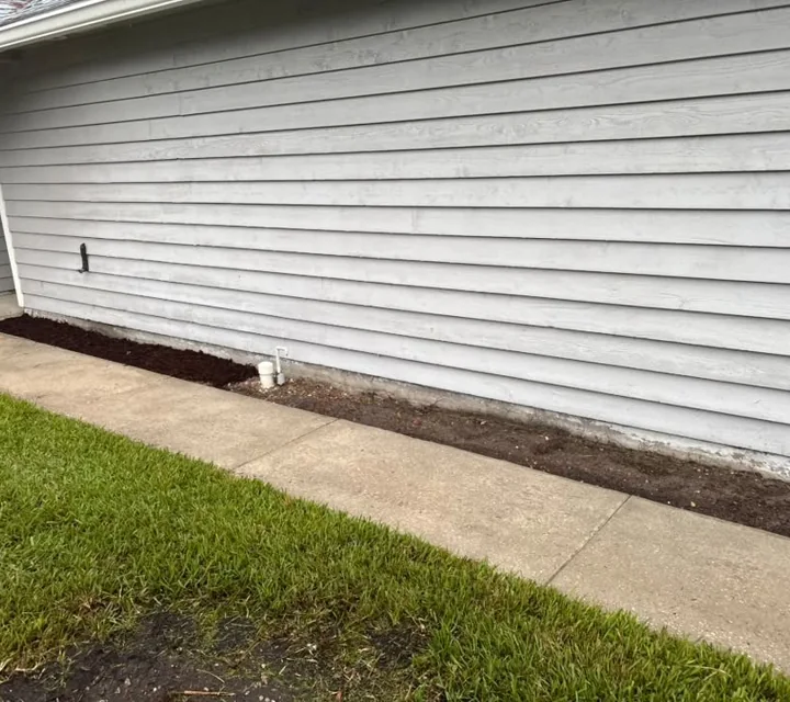 A clear concrete walkway along the side of a home